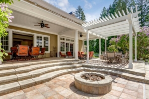 Outdoor patio with fire pit and outdoor dining table under pergola