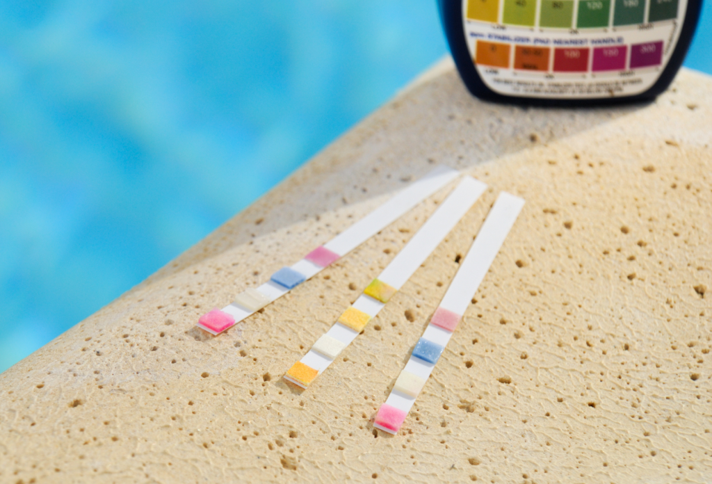 Chemical testing strips by the side of the pool.