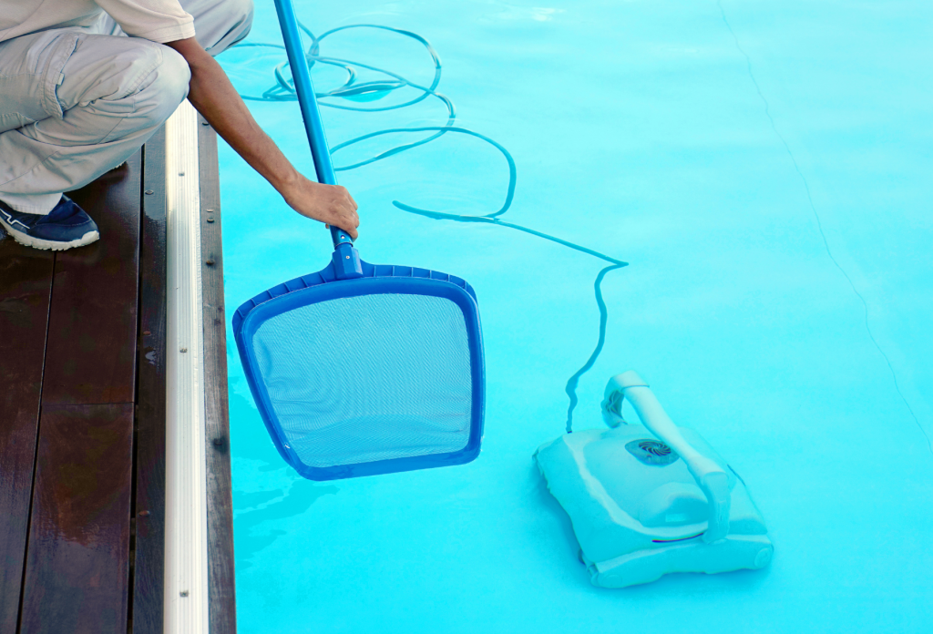 A pool cleaner taking extra care to clean their pool before completing their pool closing guide.